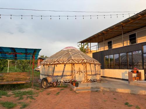a building with a yurt in front of a building at Guesthouse Snow Leopard - 'Ak Ilbirs' in Tong