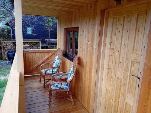 two chairs sitting on the porch of a cabin at Chata Mandl - Klid, příroda, soukromí in Řetová