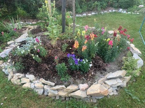 a garden with flowers and rocks in a yard at Chata Mandl - Klid, příroda, soukromí in Řetová