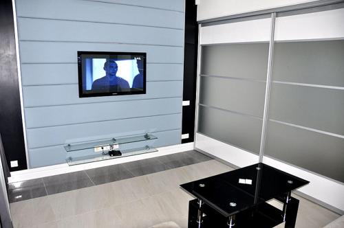 um quarto com uma televisão numa parede com uma mesa em 150 metres to Ploscha Rynok em Lviv
