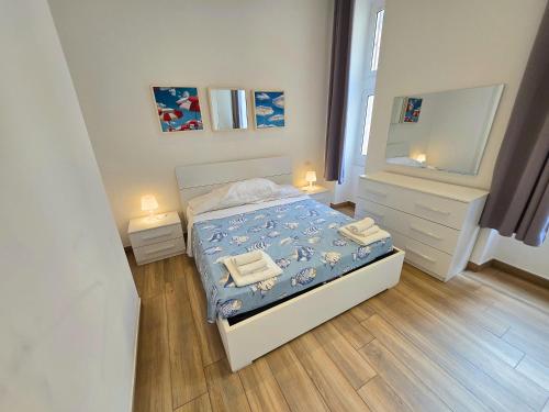 małą sypialnię z łóżkiem i lustrem w obiekcie LA CALETTA BEACH APARTMENT w mieście La Spezia