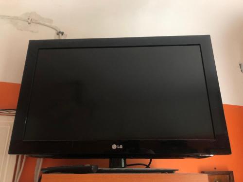 a flat screen tv sitting on a stand at Authentic apt in a rustic house, best for a person or couple in Rīga