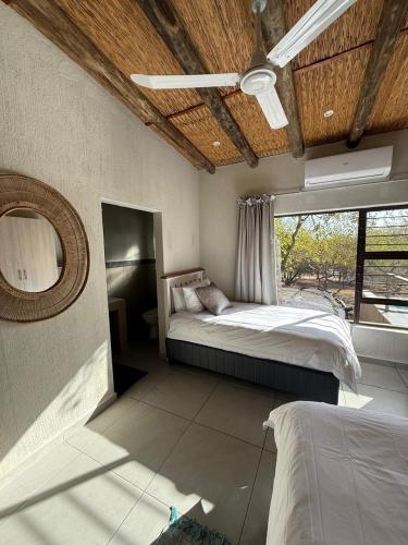 a bedroom with two beds and a ceiling fan at Ingonyama Rest in Marloth Park