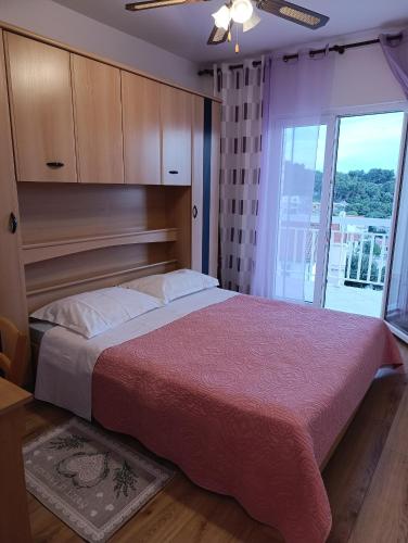 a bedroom with a large bed and a large window at Apartments Slijepcevic in Hvar