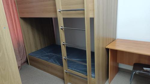 een kast met een bureau en een houten stapelbed bij Шамшырак in Zhezdi
