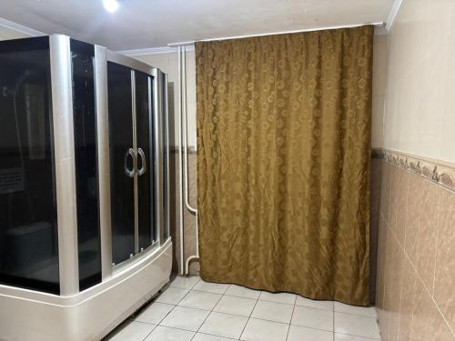 een badkamer met een douche en een gordijn bij Шамшырак in Zhezdi