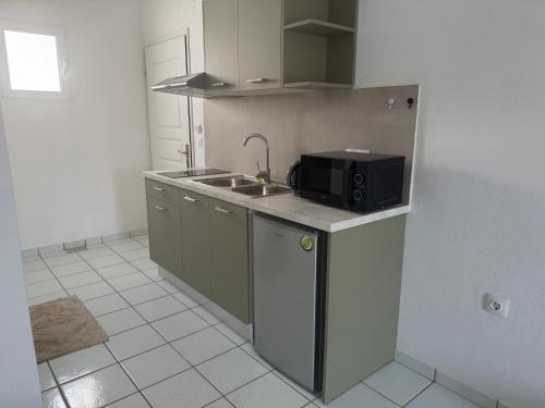 a kitchen with a sink and a microwave at Esperos Apartments&Studios in Troulos