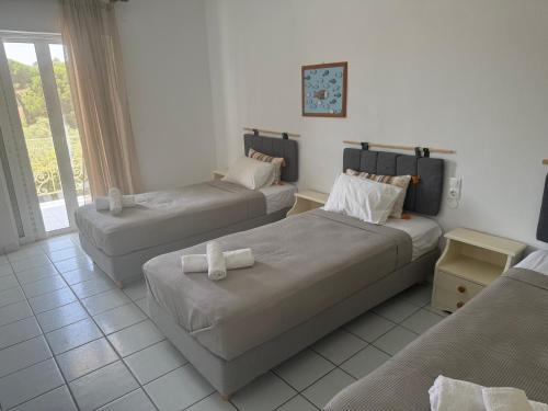 a hotel room with two beds and a couch at Esperos Apartments&Studios in Troulos