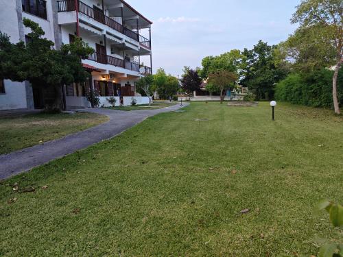 a grassy yard in front of a building at Sun And Roses Siviri in Siviri