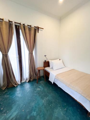 a bedroom with a bed and a table and a window at Siri Beach Lodge in Nungwi
