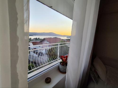 a balcony with a window with a view of a city at Wisteria in Tivat