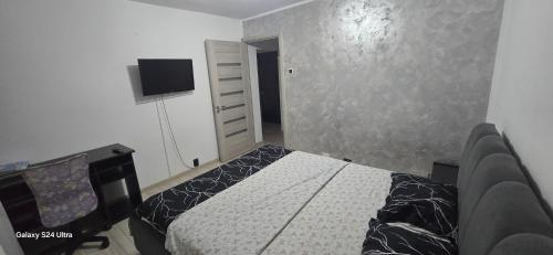 a bedroom with a bed and a tv on the wall at ILONA APARTAMENT 3 camere in Râmnicu Vâlcea