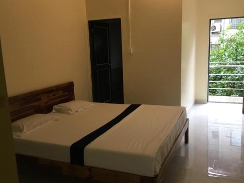 a bedroom with a bed in a room with a window at My Favourite Corner in Panchgani