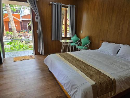 une chambre avec un lit, une table et des chaises dans l'établissement Homestay Nguyễn hưng, à Hue