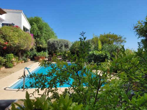 a swimming pool in the middle of a garden at Villa Naranjo Costa Blanca in L’Alfàs del Pi