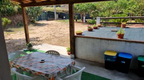 a patio with a table and chairs on a porch at Orange Villa in Capo Vaticano