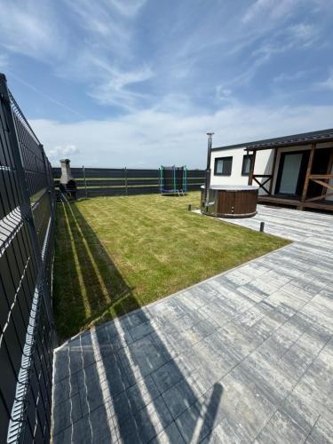 a yard with a fence and a house at SPA Vila Lotosový kvet Jasenov in Jasenov