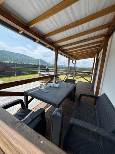 a table and chairs on a deck with a view at SPA Vila Lotosový kvet Jasenov in Jasenov