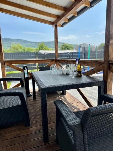 a table with glasses and bottles of wine on a deck at SPA Vila Lotosový kvet Jasenov in Jasenov