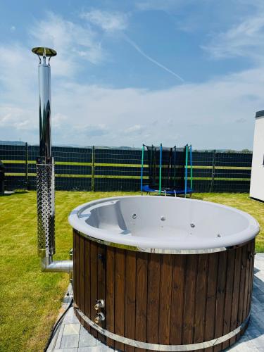 a large wooden tub sitting on top of a field at SPA Vila Lotosový kvet Jasenov in Jasenov