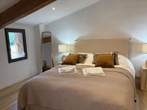 une chambre avec un grand lit avec deux serviettes dessus dans l'établissement Montmerle, à Rustrel