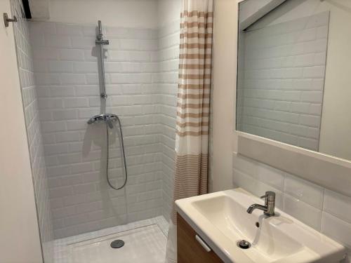 une salle de bain blanche avec un lavabo et une douche dans l'établissement Montmerle, à Rustrel