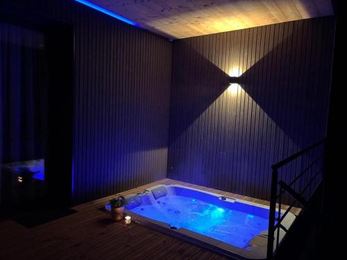 un jacuzzi dans une pièce avec un éclairage violet dans l'établissement Le Black Sheep Gîtes & Spa Privatif Sarlat, à Sarlat-la-Canéda