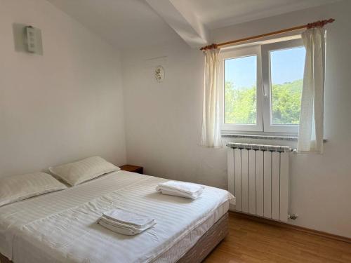 a bedroom with a bed with two towels on it at VILLA STASJA in Brseč