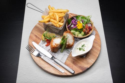 a plate of food with a salad and french fries at L'Hôtel et Restaurant du Golf de Clervaux in Eselborn