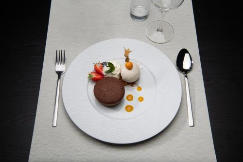 a white plate with a chocolate dessert on a table at L'Hôtel et Restaurant du Golf de Clervaux in Eselborn