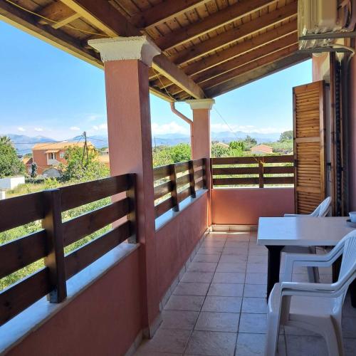 a patio with a table and chairs on a balcony at Olga's Garden Apartments in Almiros Beach