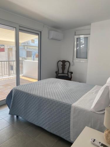 a bedroom with a bed and a chair and a window at Marianna's penthouse at Exarcheia square in Athens