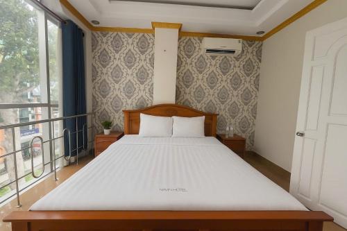 a bed in a bedroom with a large window at LuxuryK&T Hotel-Near Bùi Viện Walking Street in Ho Chi Minh City