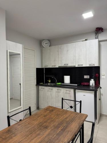 a kitchen with a wooden table and a table and chairs at Milla Lux 3 in Paralia Katerinis
