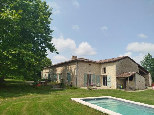 une vieille maison avec une piscine en face de celle-ci dans l'établissement Le Haut Séchoir, à Buzet-sur-Baïse