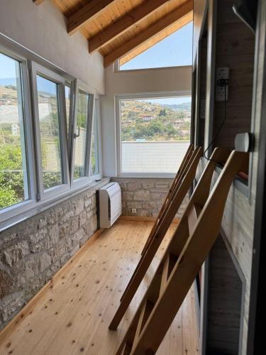 a tiny house with a staircase with windows at Himara Hostel in Himare