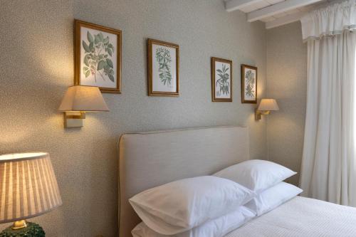 a bedroom with a white bed and pictures on the wall at Despotiko Hotel in Mýkonos City
