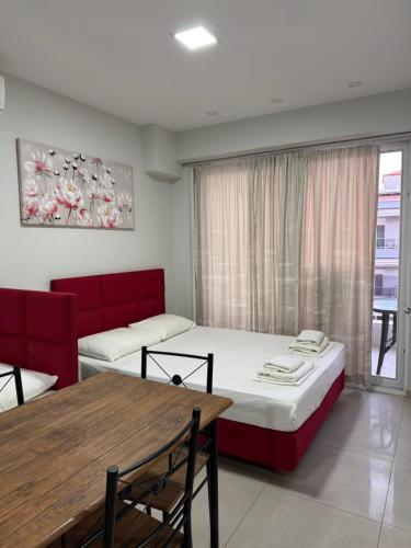 a room with two beds and a table and a window at Milla Lux 3 in Paralia Katerinis