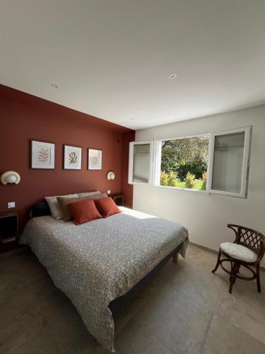 une chambre avec un grand lit et une fenêtre dans l'établissement Rez-de-villa avec terrasse privative sur jardin, à Ajaccio