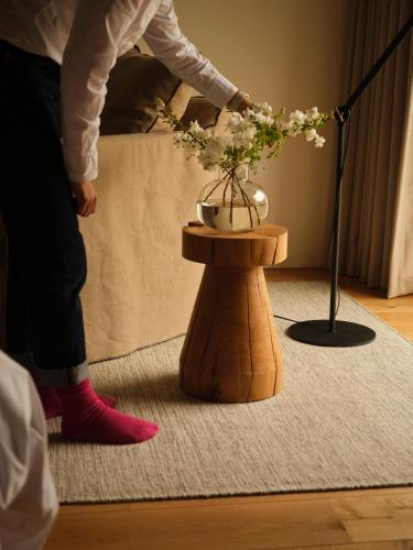 a person in red boots arranging a vase on a table at Fowlescombe Farm in Ugborough