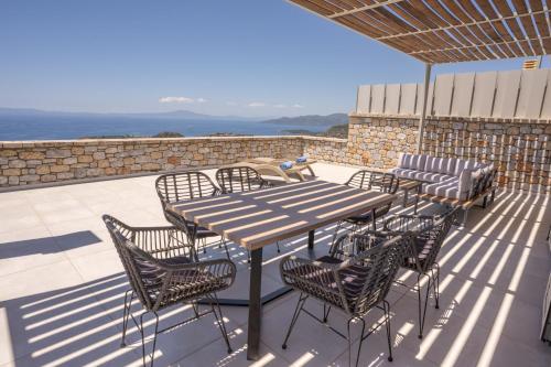 a wooden table and chairs on a patio at Pasithea in Neokhórion