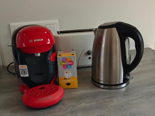 a red and black coffee maker next to a box at Maison avec Spa en bord de mer in Logonna-Daoulas