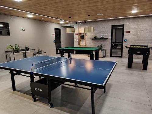 a ping pong table in a room with two tables at La Dolce Vita in Maceió