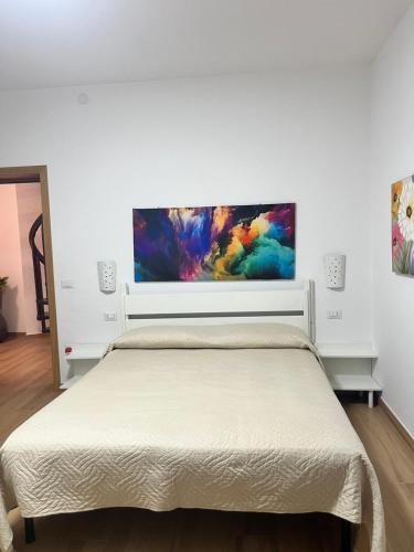 a bedroom with a bed and a painting on the wall at Villa Andres in Sassari