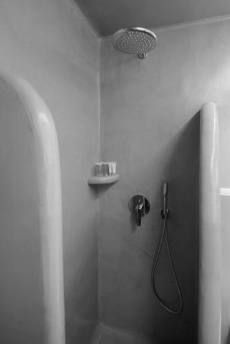 a bathroom with a shower with a shower head at Tataki Family Hotel in Fira