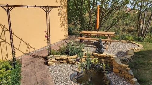 a park bench and a statue in a garden at Unterkunft FERIENHAUS "HUMMELCASA" IM HUMMELGAU UNWEIT BAYREUTH FÜR MAX 5 PERSONEN in Creez