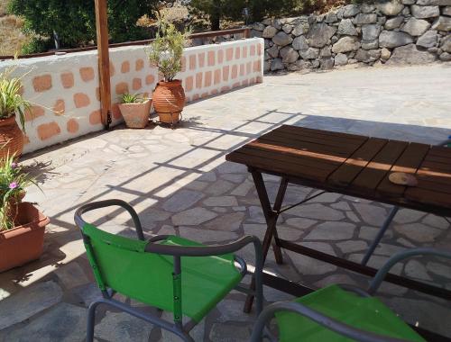 a table and a green chair next to a table at Marietta Studios Patmos in Skala