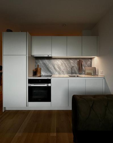 a kitchen with white cabinets and a sink at Business Apartment Baden Central Station in Baden