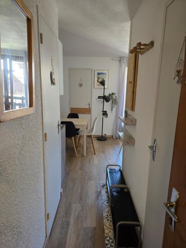 un couloir avec une chambre dotée d'une table et d'une chaise dans l'établissement Appartement chaleureux, à Risoul