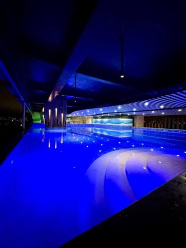 a swimming pool with blue lights in a building at The Hmlet Manila, Near Poblacion Makati Nightlife in Manila